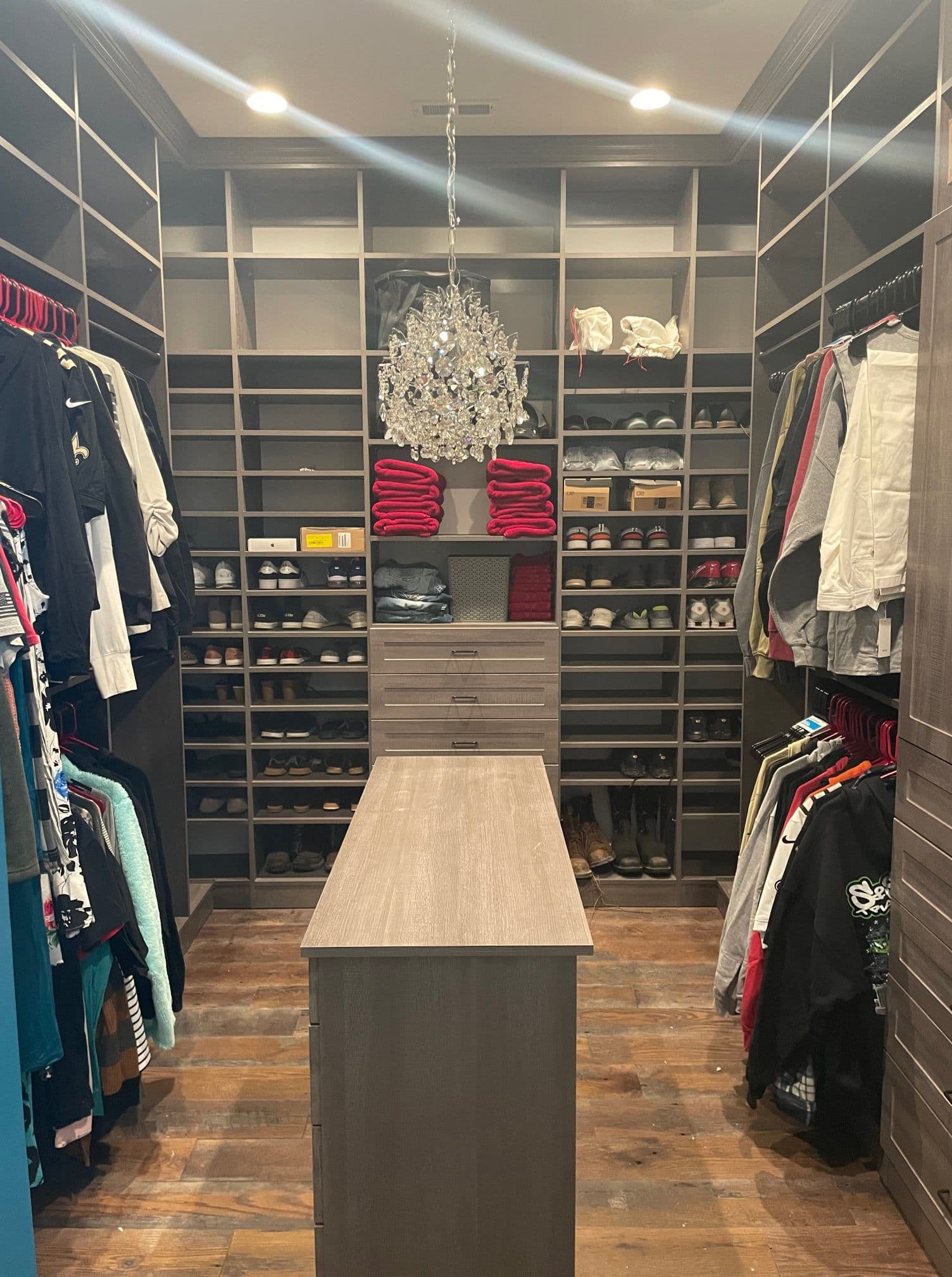 Custom walk-in closet with chandelier and island in mid-Missouri home